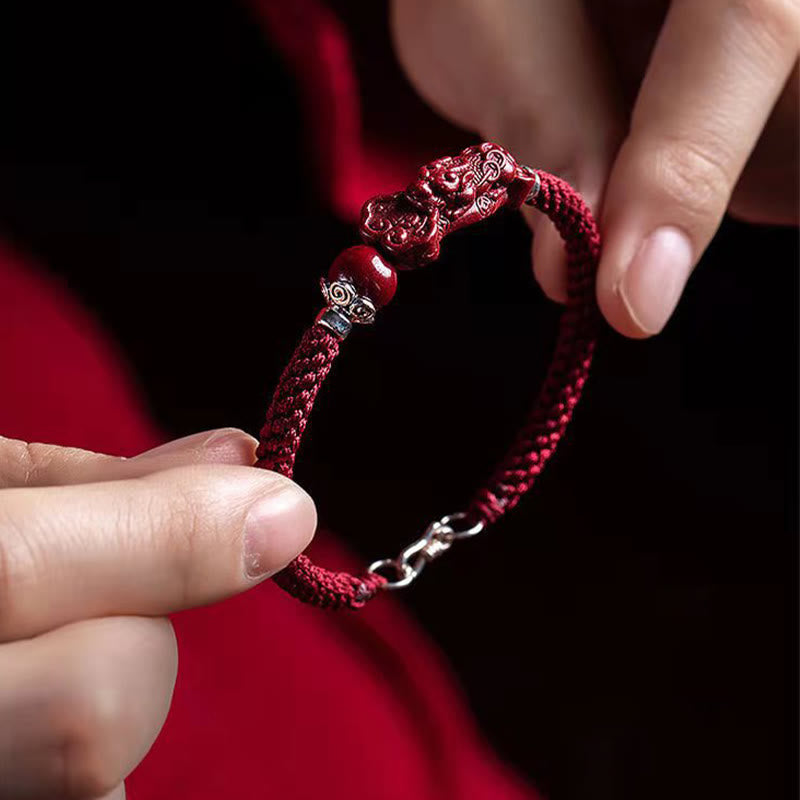 Zinnober Pixiu Armband Glück Wohlstand rote Kordel Nahaufnahme Handgelenk getragen