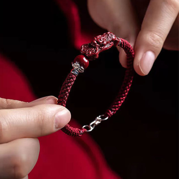 Zinnober Pixiu Armband Glück Wohlstand rote Kordel Nahaufnahme Handgelenk getragen
