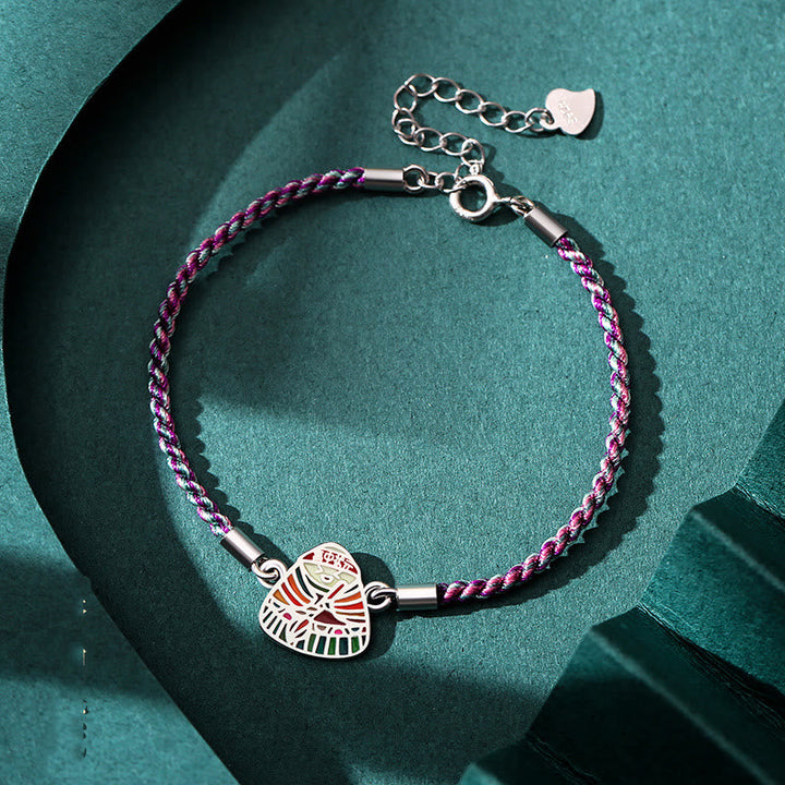 Lila Seidenarmband mit silbernem Glücksanhänger elegant getragen