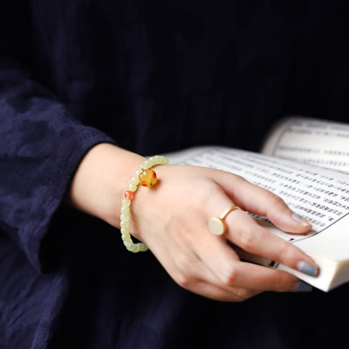 Armband Roter Achat Kristall am Handgelenk mit Buch getragen