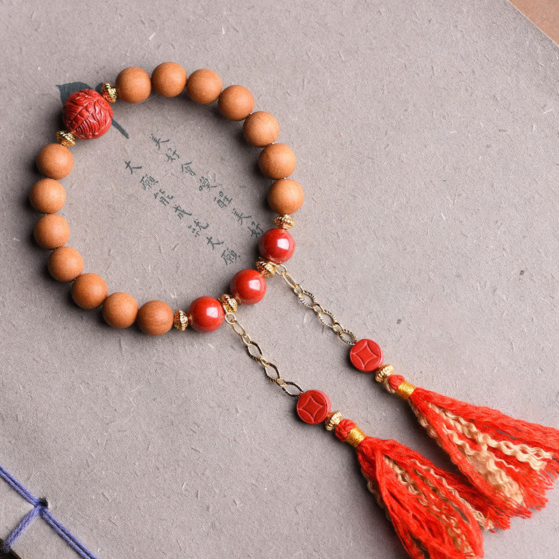 Armband mit Holzperlen, roten Steinen und Quasten Anhänger.