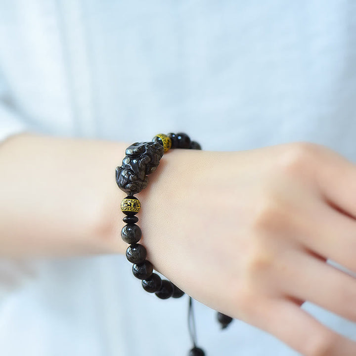 Schwarzes Obsidian Armband mit Om Mani Padme Hum Anhänger am Handgelenk