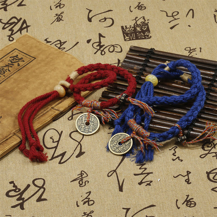 Rotes und blaues Armband mit Münzen auf Schrifttafel.