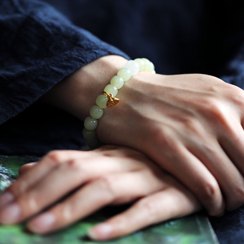 Jade Lotus Armband am Handgelenk, grüne Perlen mit goldener Lotusblüte Charm