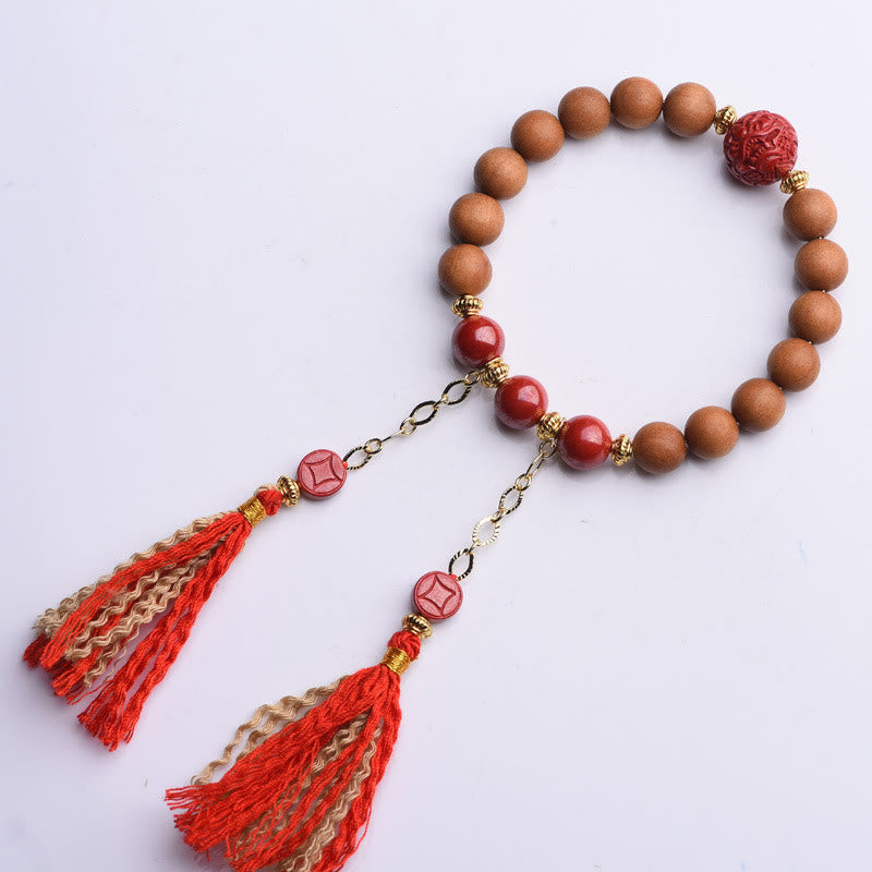 Armband Zinnober Pixiu mit Holzperlen und roten Quasten elegant.
