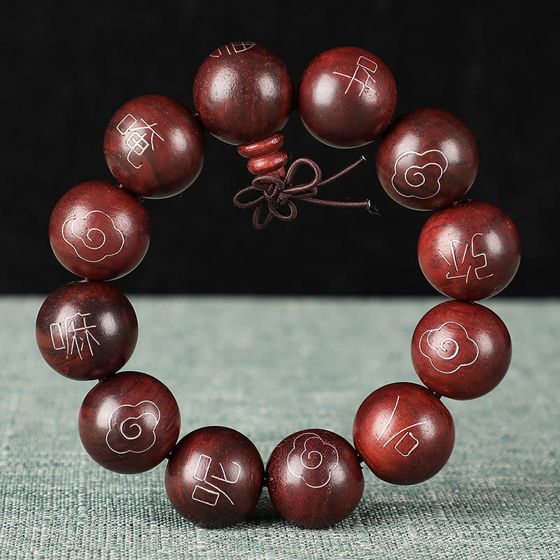 Rotes Sandelholz Armband mit eingraviertem Om Mani Padme Hum Symbol.