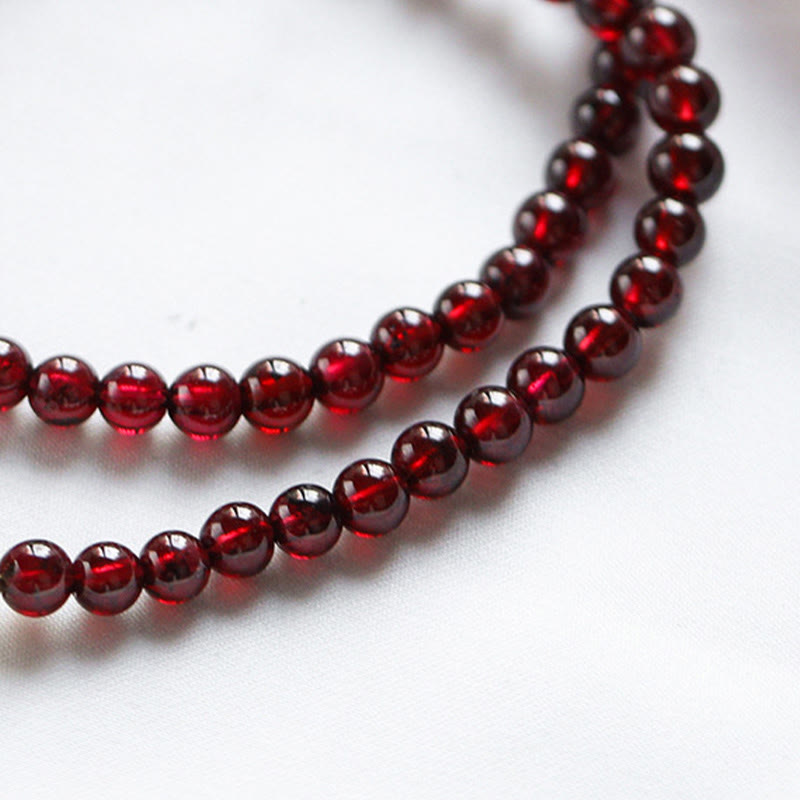Rotes Granat Armband mit glänzenden Perlen auf weißem Hintergrund.