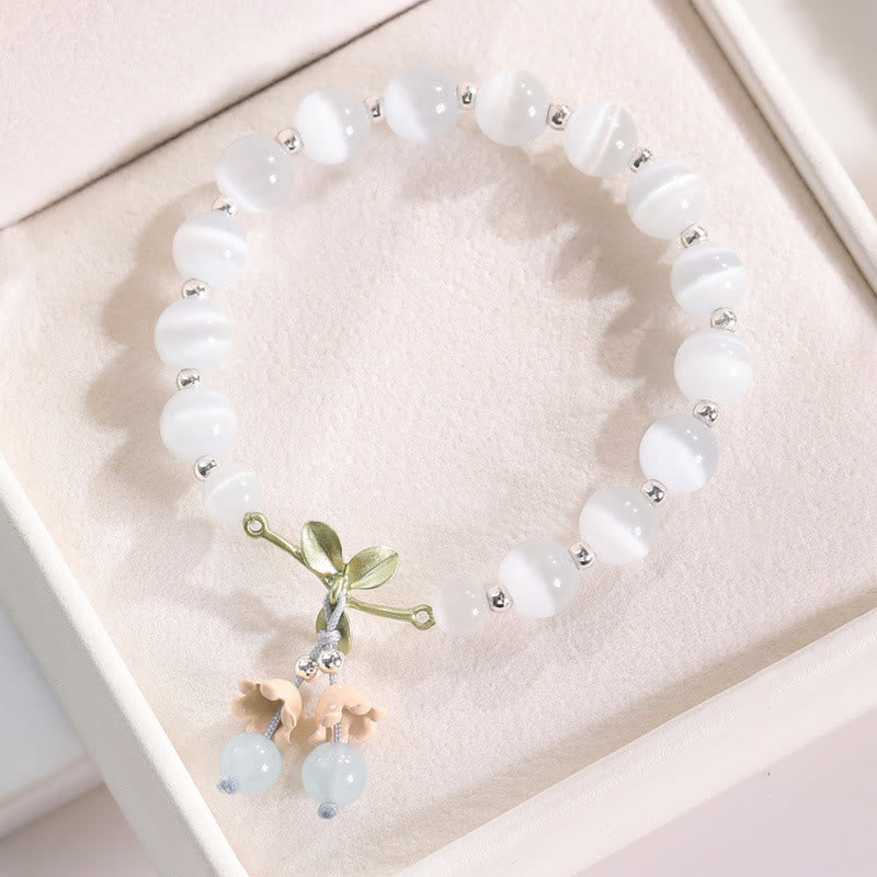 Weißes Perlenarmband mit grüner Schleife und Katzen-Anhänger Kristall