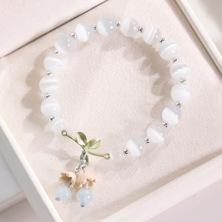 Weißes Perlenarmband mit grüner Schleife und Katzen-Anhänger Kristall