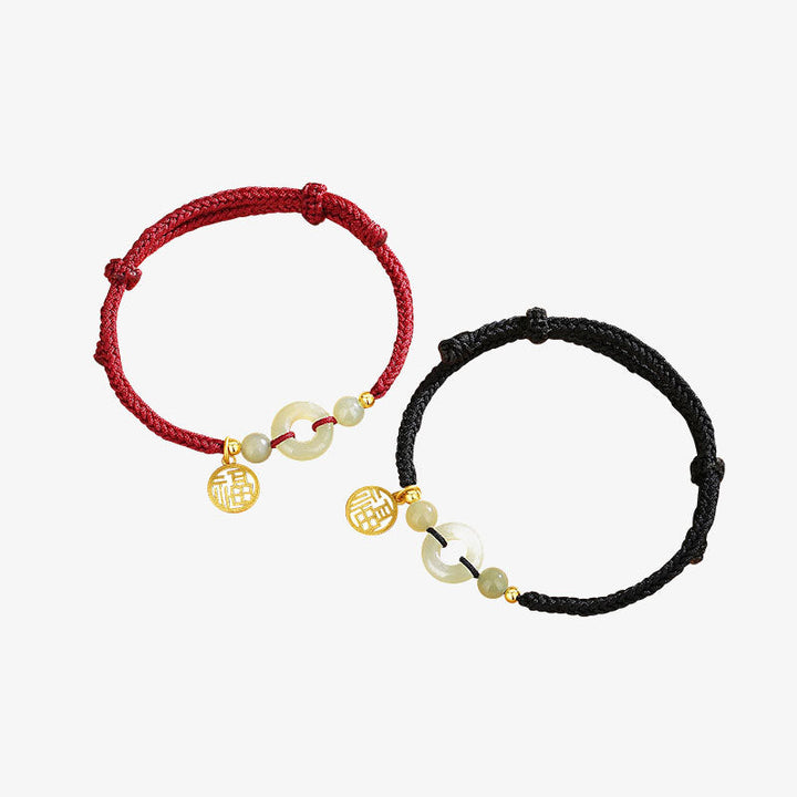 Zwei Jade-Armbänder mit goldenem Fu-Zeichen Anhänger elastisch.