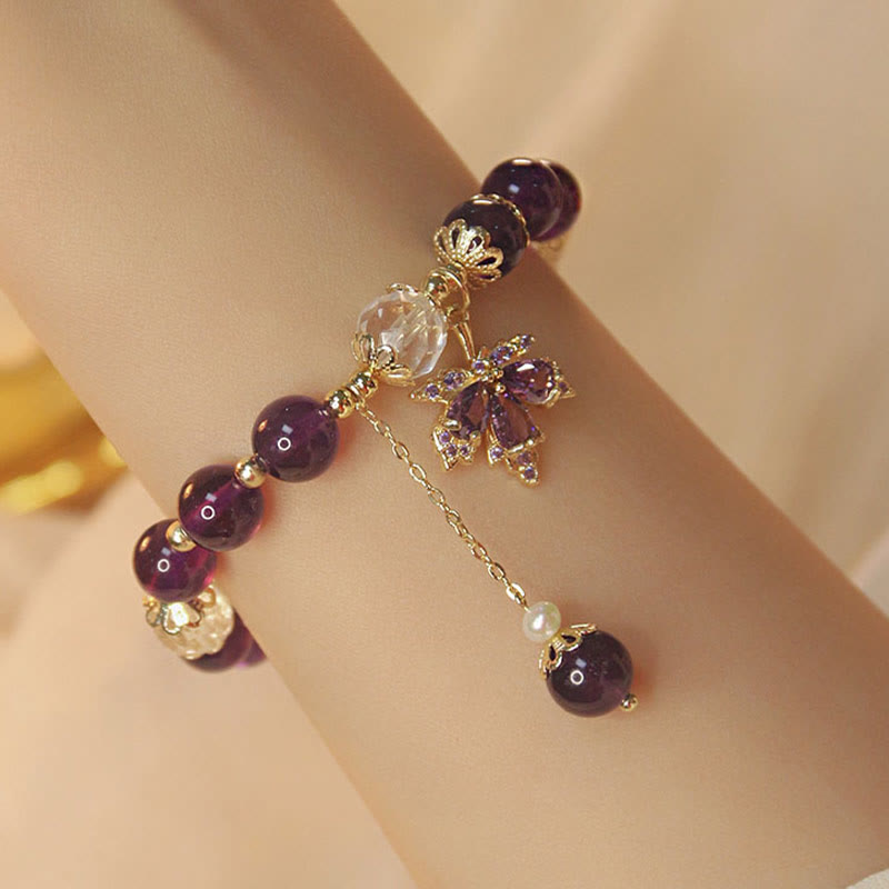 Armband Amethyst mit Perlen und Blütenanhänger am Handgelenk getragen