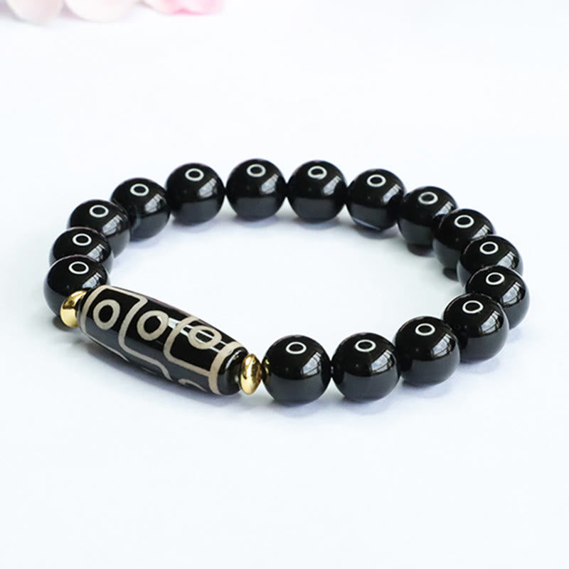 Armband Schwarzer Onyx mit graviertem Zylinder und goldenen Akzenten elastisch.