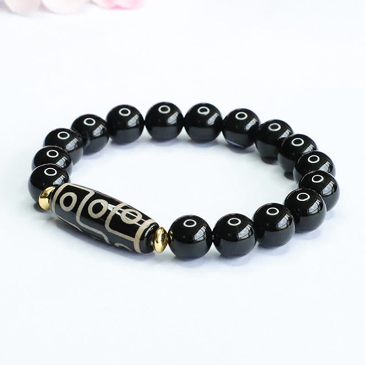 Armband Schwarzer Onyx mit graviertem Zylinder und goldenen Akzenten elastisch.