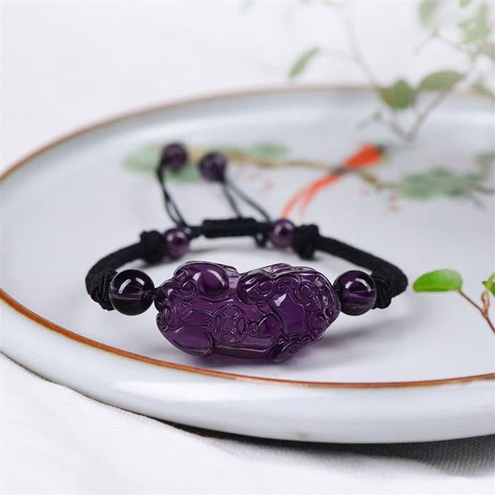 Lila Pixiu Armband mit Amethyst Perlen auf weißem Teller Schmuck