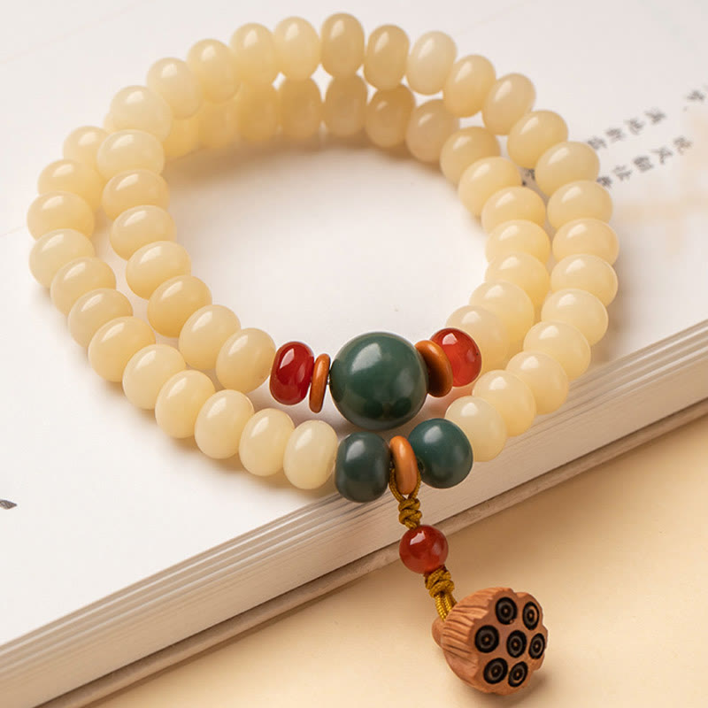Bodhi Lotus Armband mit cremefarbenen Perlen und grünem Anhänger elegant.