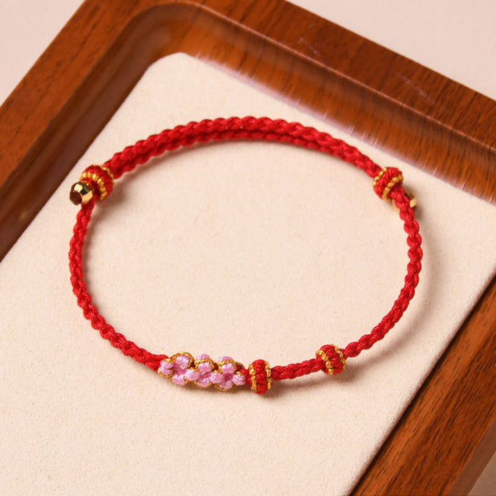 Rotes Armband Pfirsichblüte – Schutz mit rosa Perlen elastisch.