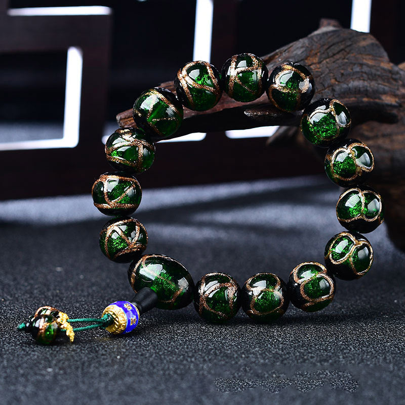 Grünes Achat Drachen-Armband mit goldenen Perlen elegant präsentiert.