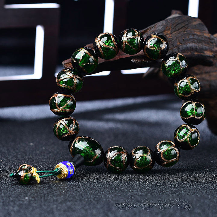 Grünes Achat Drachen-Armband mit goldenen Perlen elegant präsentiert.