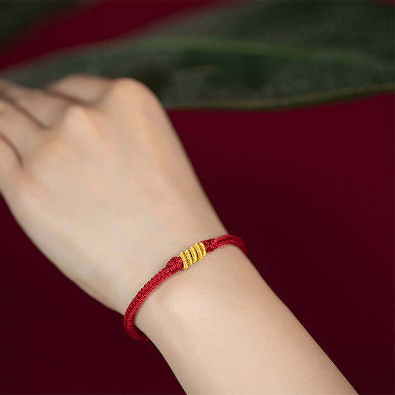 Rotes Armband – Schutz & Glück Energie mit goldfarbenen Elementen am Handgelenk