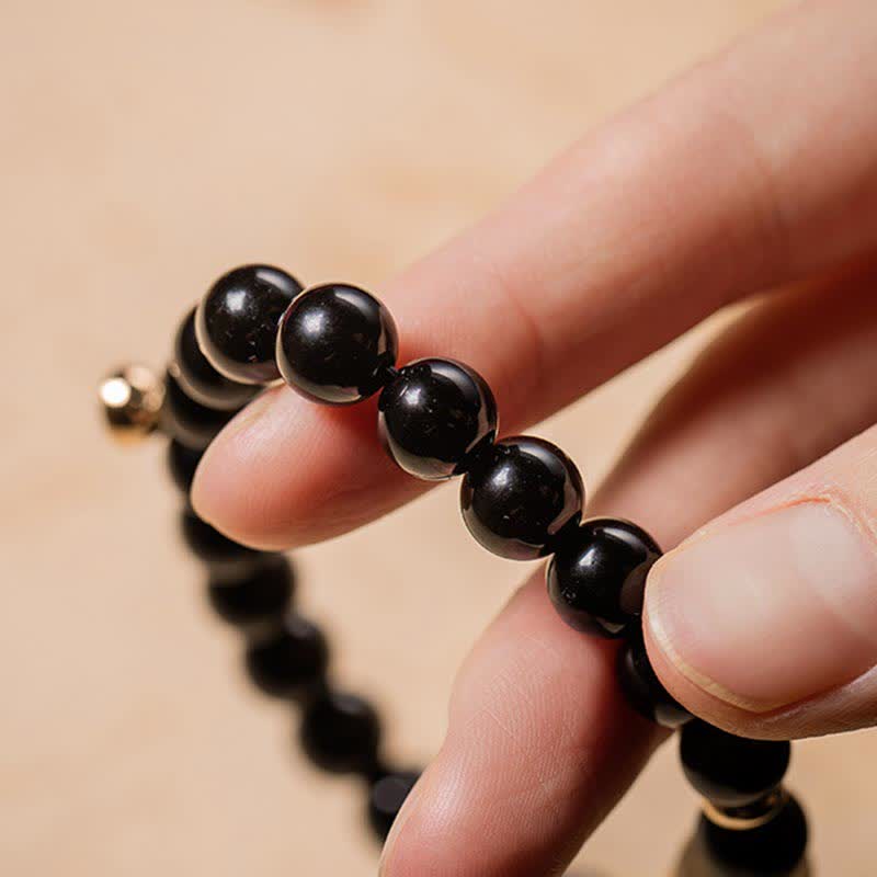 Schwarzer Obsidian Armband elastisch am Handgelenk getragen Naturstein Perlen