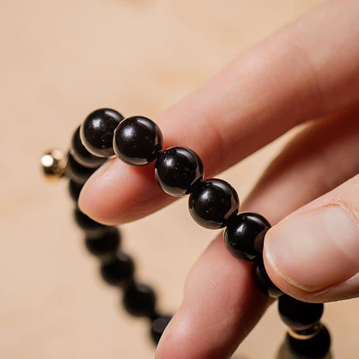 Schwarzer Obsidian Armband elastisch am Handgelenk getragen Naturstein Perlen
