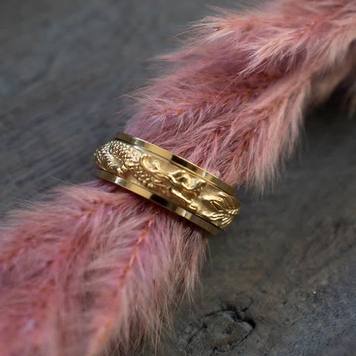 Ring Drachen Titanstahl goldfarben strukturiert auf rosa Fell Fengshui