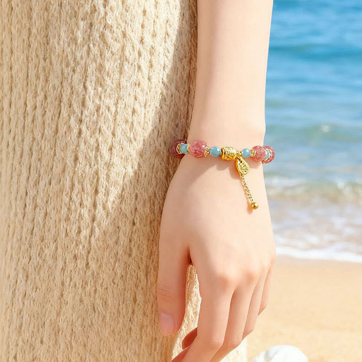 Armband Erdbeerquarz Mondstein Mond Heilung Positivität am Handgelenk Strand