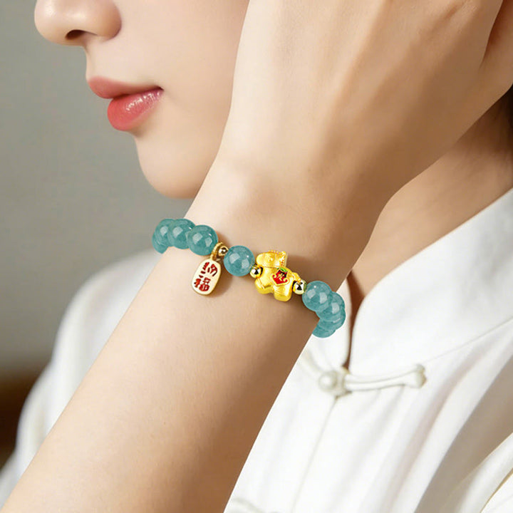 Armband Jade – Fülle & Wohlstand mit goldener Glückskatze am Handgelenk getragen