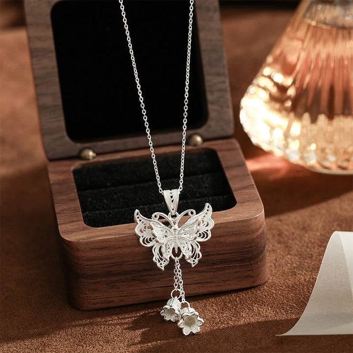 Silberne Kette mit Schmetterling Maiglöckchen Anhänger auf Holzständer