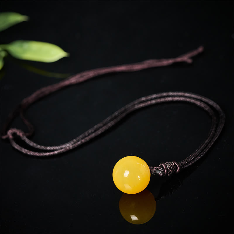 Gelbstein Kette Anhänger schwarze Schnur eleganter Balance Naturstein