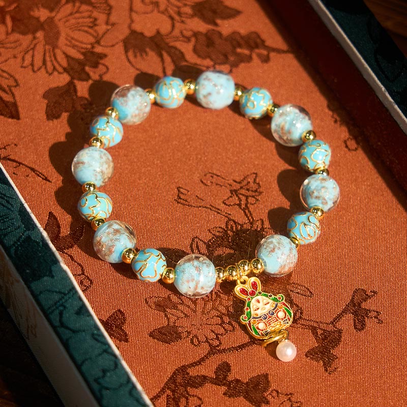 Armband Liuli Hase – Glück mit hellblauen Perlen und goldenem Hasenanhänger im Schmuckkästchen