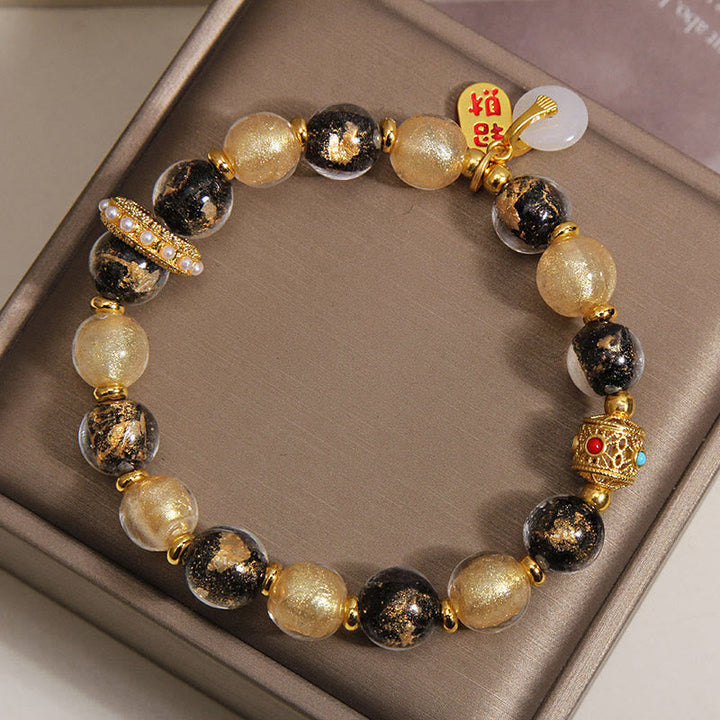 Armband Liuli – Wohlstand & Frieden mit goldenem Anhänger am Handgelenk getragen