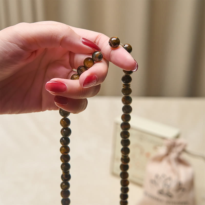 Armband Tigerauge Lotus – Stärke an Hand mit Mala Perlen getragen