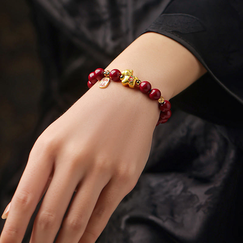 Armband Zinnober Pferd – Segen rote Perlen goldener Anhänger Handgelenk getragen