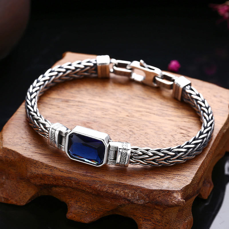 Armband Drachen Heilung Wohlstand Silber mit blauem Edelstein auf Holzpodest