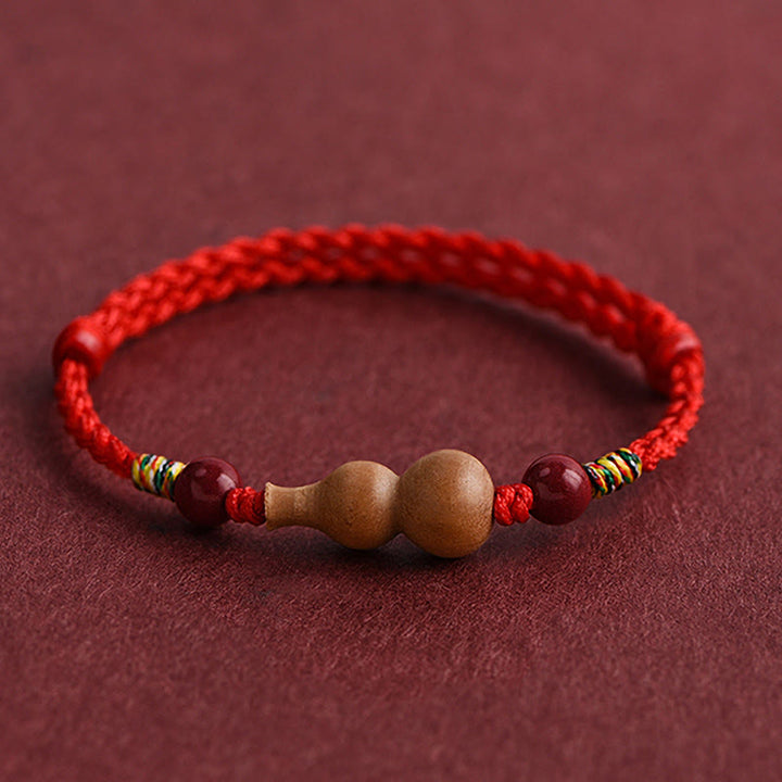 Armband Pfirsichholz Glück Wohlstand Kalebasse rote Kordel handgeflochten Schutz