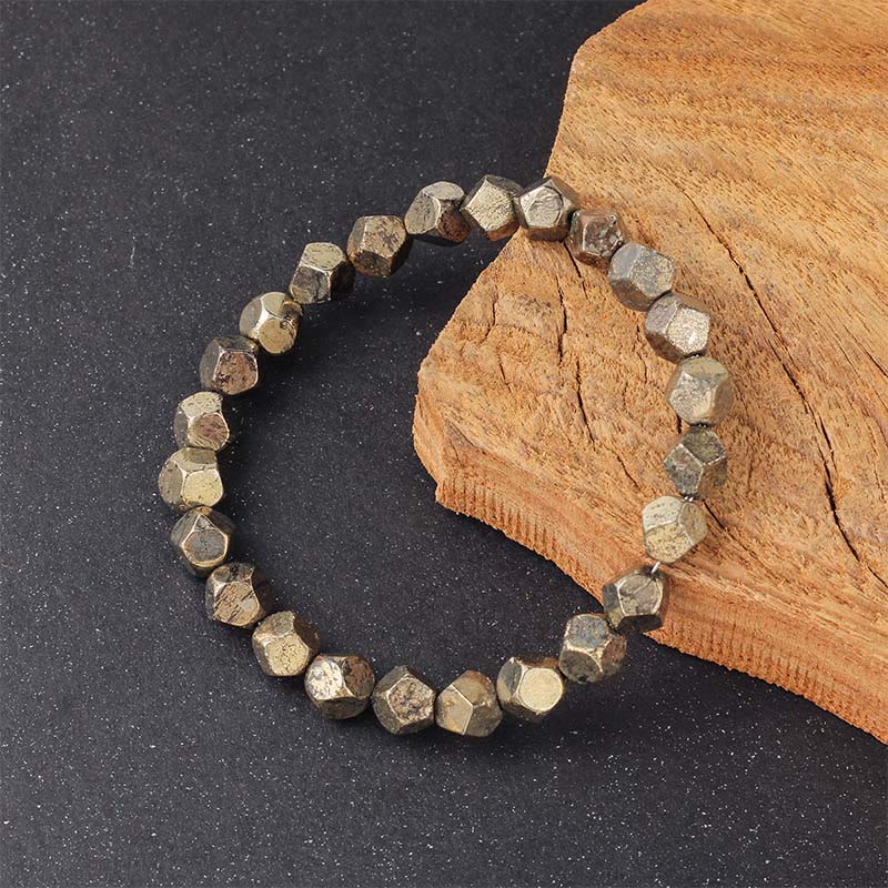 Armband Pyrit Buddha Schutz Vertrauen facettierte Perlen auf Holz