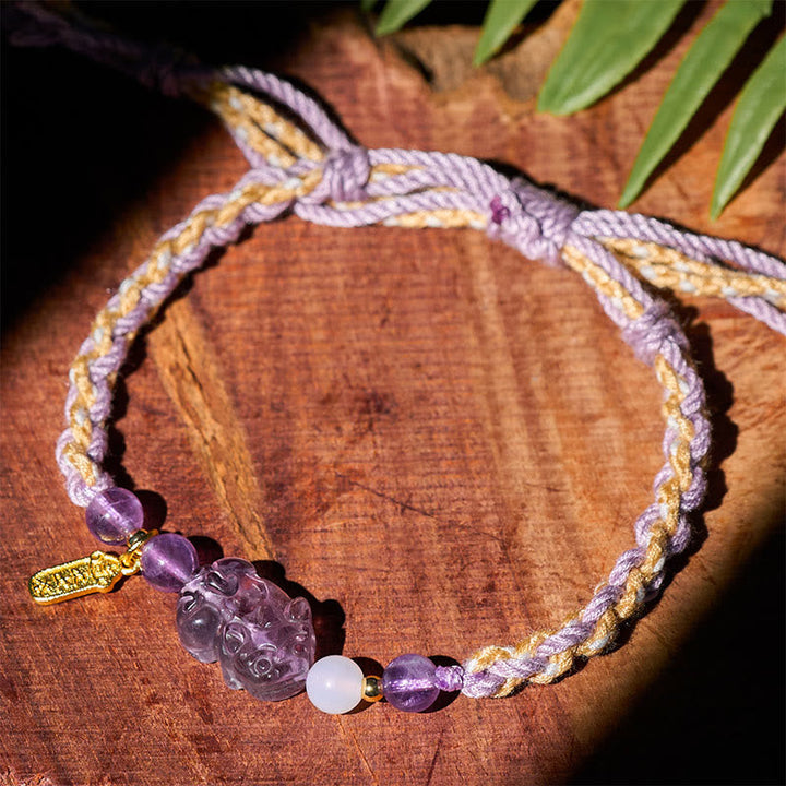Armband Amethyst Pixiu Glück Balance geflochten lila Holzhintergrund Fengshui Schutz