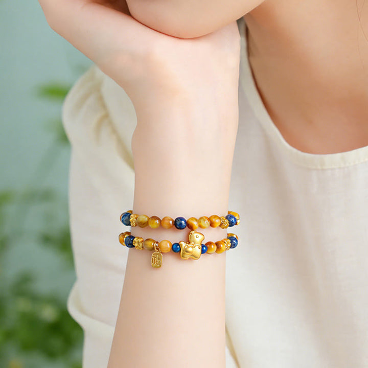 Armband Lapislazuli Tigerauge Fu-Zeichen Pixiu am Handgelenk getragen Glück