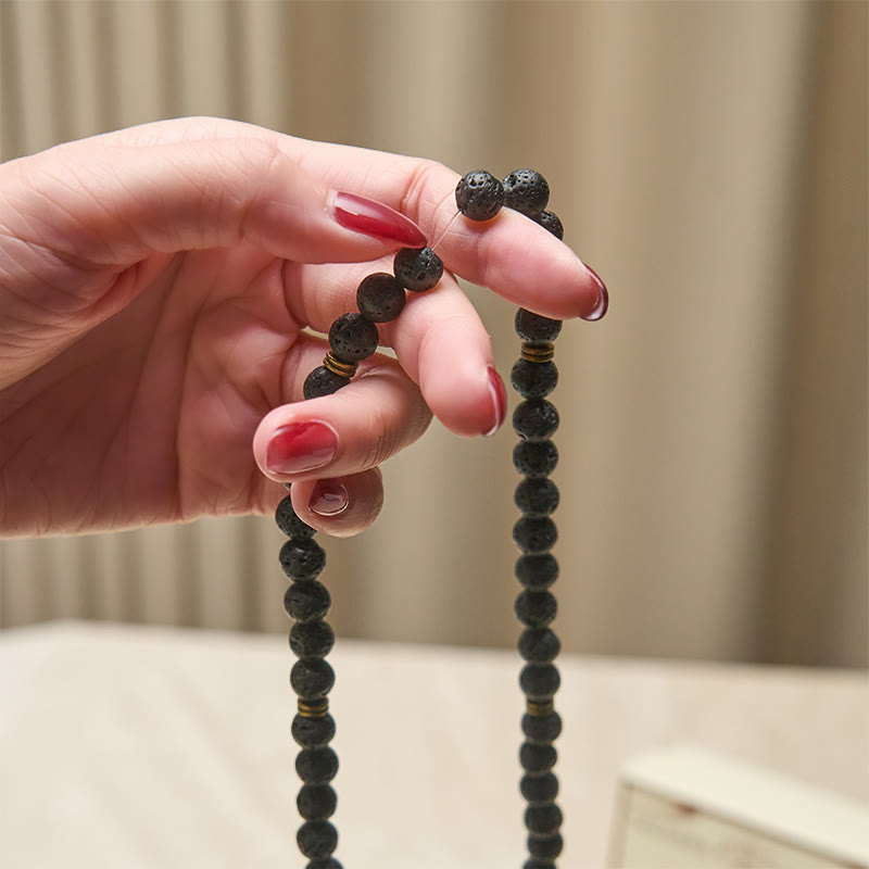 Armband Lavastein Lotus Heilung schwarze Perlen in Hand getragen Mala