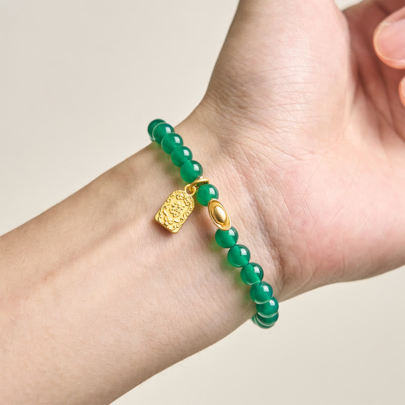 Armband Achat Fu-Zeichen grüne Perlen goldener Anhänger am Handgelenk getragen