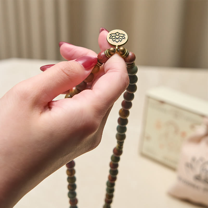 Armband Türkis Lotus – Energie aus Holzperlen mit Lotus Anhänger Handgelenk