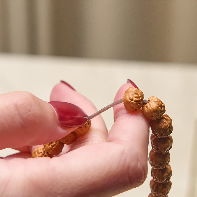 Mala Bodhi – Wohlstand Harmonie Armband aus Bodhi Samen in Hand gehalten