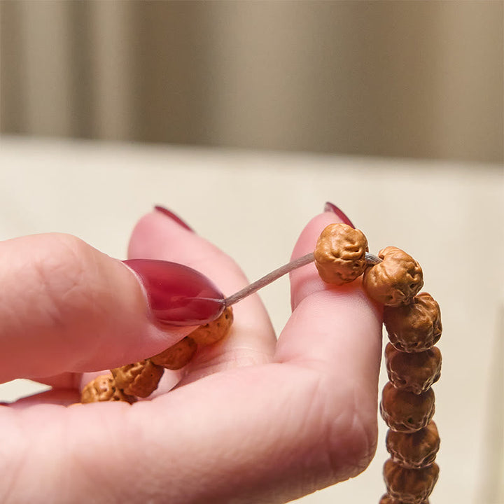 Mala Bodhi – Wohlstand Harmonie Armband aus Bodhi Samen in Hand gehalten