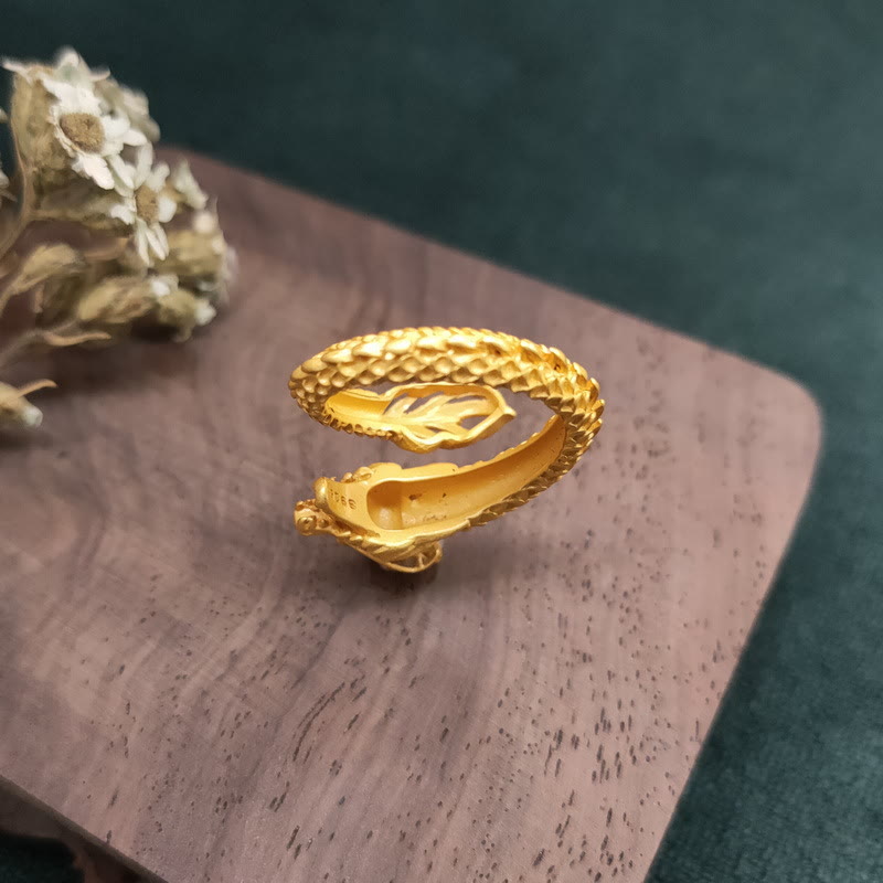 Goldener Drachen Ring mit Erfolgs- und Stärkesymbolik auf Holzoberfläche