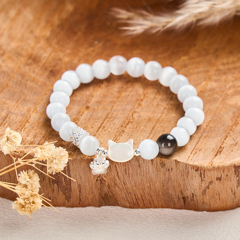 Armband Silber Obsidian Katze Positivität weiße Perlen Holzuntergrund Trockenblumen