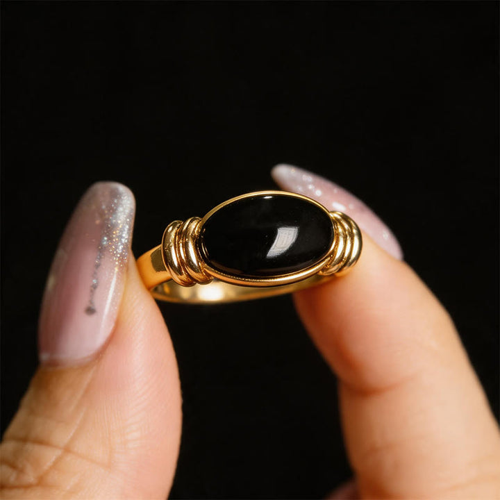 Ring Hämatit Ovalmuster mit goldfarbener Fassung und schwarzem Stein