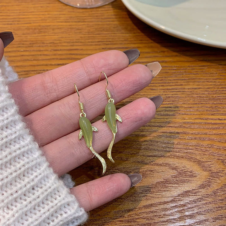 Ohrringe Jade Fisch Glück getragen Hand Holztisch Boho Schmuck spirituell