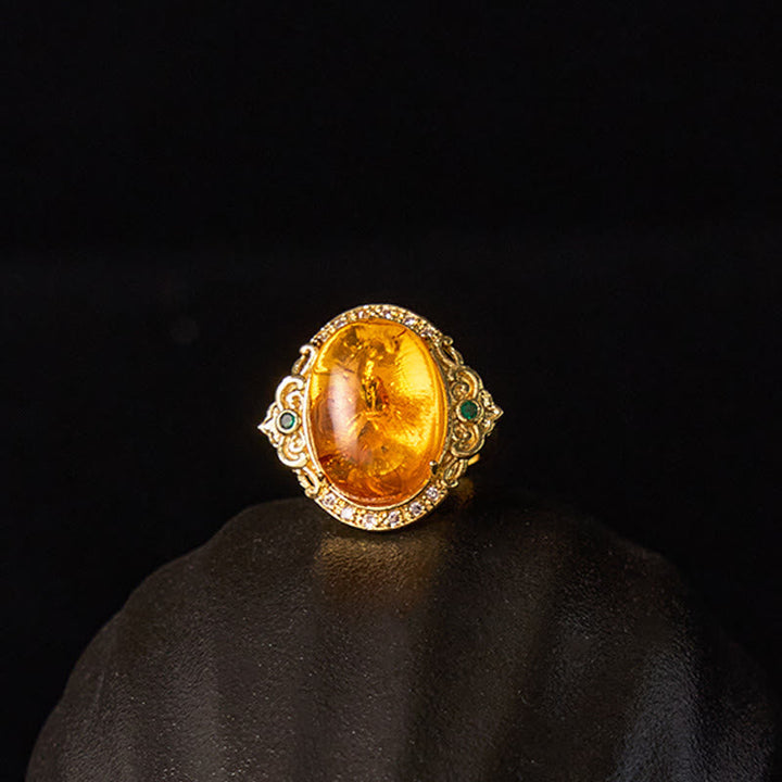 Bernstein Ring Blume Taubenmuster Klarheit grüne Akzente eleganter Schmuck