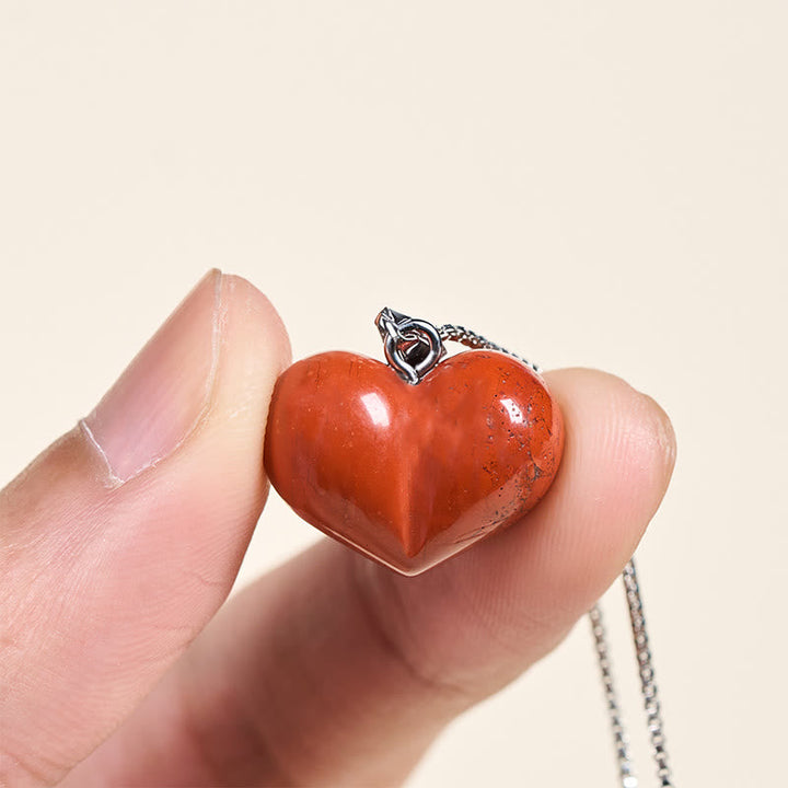 Roter Herz Anhänger Kette in Hand Balance Naturstein Symbol